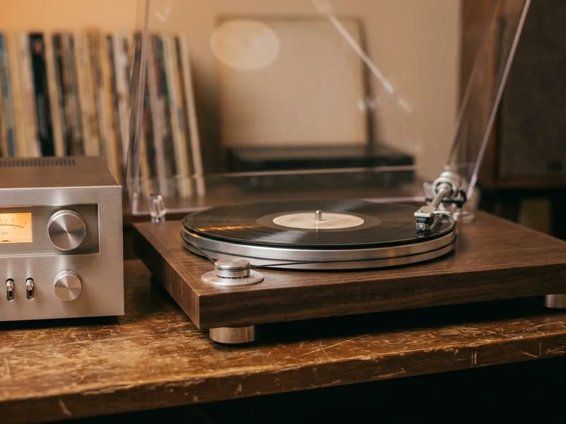 A 1970s wood-plinth turntable beside a silver receiver with glowing meters